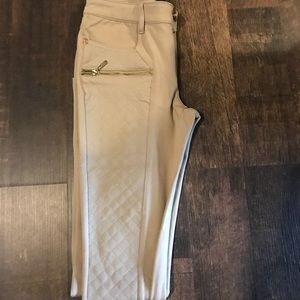 Tan pants with gold zippers.